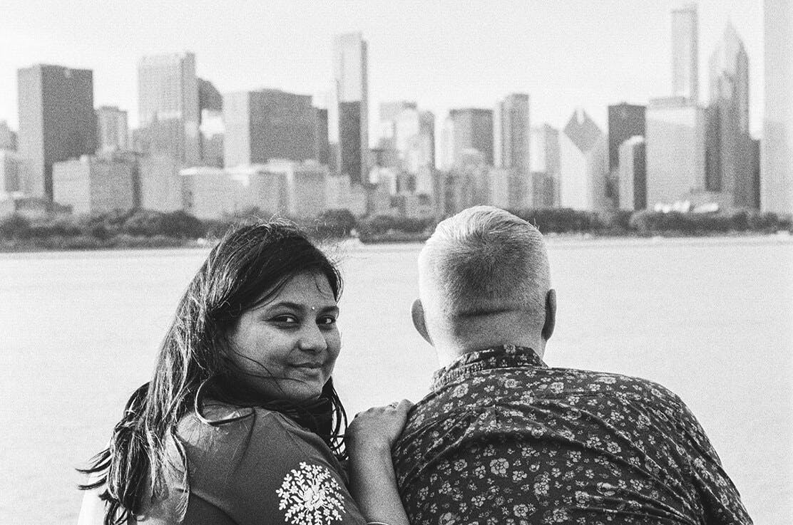 A black and white photo of Shaila and Jeremy overlooking Chicago from Adler Planetarium